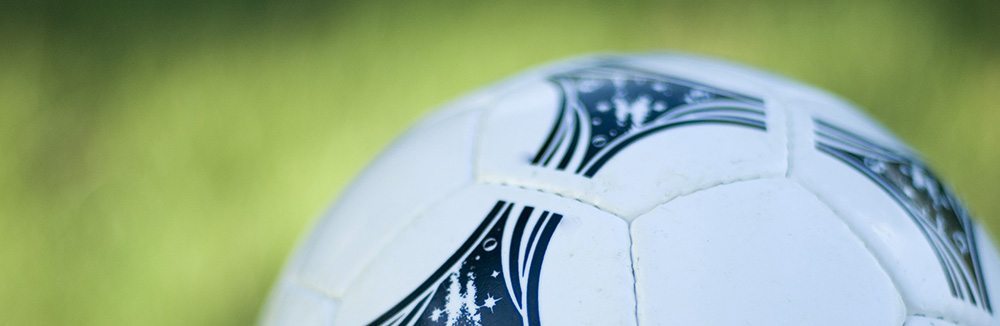 a white and black soccer ball with a green grass background